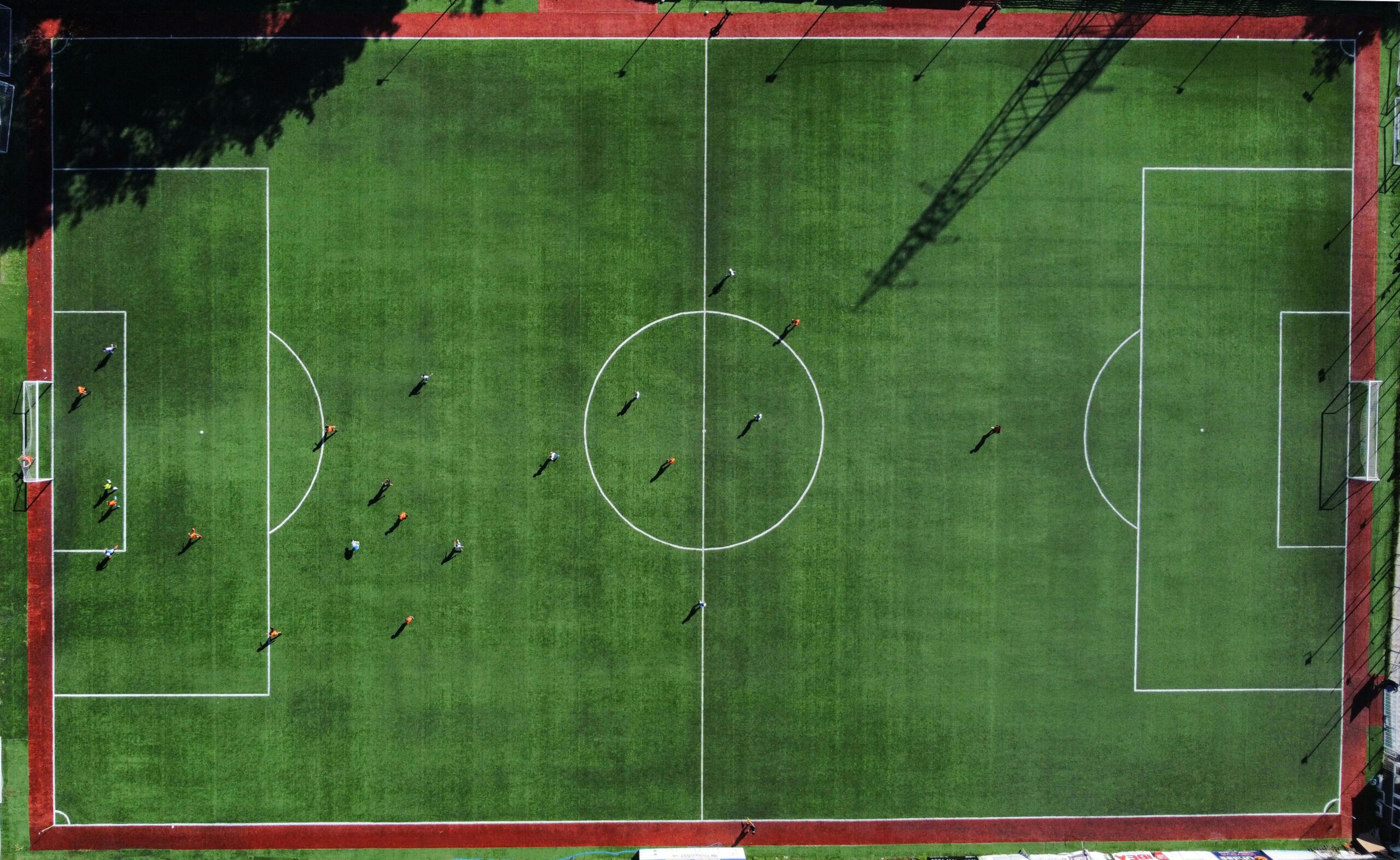 Fußballplatz für Jugendturniere aus der Vogelperspektive mit Fußballspielern, die darauf ein Fußballspiel spielen.